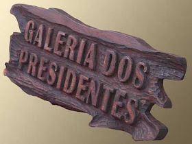 Placa de cedro com bordas orgânicas e o texto "Galeria dos Presidentes" entalhado em altíssimo alto relevo com acabamento em verniz marítimo fosco